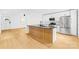 Modern kitchen features a black countertop island with natural wood accent, white cabinetry, and stainless steel appliances at 1409 Effingham Rd, Charlotte, NC 28208