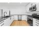 Modern kitchen features stainless appliances, black countertops, white cabinets and hardwood floors at 1409 Effingham Rd, Charlotte, NC 28208
