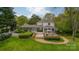Expansive backyard with lush greenery, mature trees, a beautiful stone patio, and a screened porch at 1529 S Wendover Rd, Charlotte, NC 28211