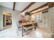 Cozy dining area with exposed beams, brick accent wall, and views into the bedroom at 1529 S Wendover Rd, Charlotte, NC 28211