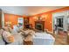 Comfortable living room with cozy seating, fireplace, hardwood floors, and warm, orange walls at 1529 S Wendover Rd, Charlotte, NC 28211