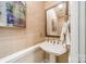 Stylish powder room featuring grasscloth wallpaper, a pedestal sink, and elegant fixtures at 1529 S Wendover Rd, Charlotte, NC 28211