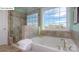 Bright bathroom with a soaking tub, glass-enclosed shower, and a large window with a scenic view at 158 Ventor Way, Mooresville, NC 28115