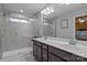 Modern bathroom with double sinks, a large mirror, and a glass-enclosed shower for a spa-like experience at 16038 Red Buckeye Ln, Huntersville, NC 28078
