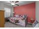 Cozy bedroom featuring a trundle bed with colorful decor, a ceiling fan and a window with sheer curtains at 16038 Red Buckeye Ln, Huntersville, NC 28078