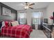Comfortable bedroom featuring a ceiling fan, a red plaid comforter, and windows that fill the room with natural light at 16038 Red Buckeye Ln, Huntersville, NC 28078