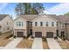 Charming townhome showcasing a well-manicured lawn, attached garages, and a welcoming two-story facade at 16038 Red Buckeye Ln, Huntersville, NC 28078