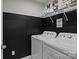Practical laundry room with modern washer and dryer, complemented by stylish black and white decor and shelving at 16038 Red Buckeye Ln, Huntersville, NC 28078