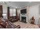 Cozy living room with a brick fireplace, comfortable leather seating, and stylish decor at 16038 Red Buckeye Ln, Huntersville, NC 28078