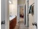 A well-lit bathroom featuring a double sink vanity, tiled floors and access to an additional room at 16614 Ruby Hill Pl, Charlotte, NC 28278