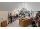 Attic bonus room with a comfortable couch, desk, and shelves for decor at 16614 Ruby Hill Pl, Charlotte, NC 28278