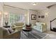 Cozy living room featuring matching sofas, a striped rug, and a large window at 16614 Ruby Hill Pl, Charlotte, NC 28278