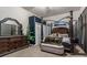 This primary bedroom boasts a beautiful four-poster bed, a matching dresser and a cozy sitting bench at 16614 Ruby Hill Pl, Charlotte, NC 28278
