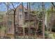 Brick home with multiple decks and a screened porch surrounded by lush trees, providing privacy at 16614 Ruby Hill Pl, Charlotte, NC 28278