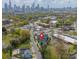 An aerial view of a neighborhood featuring a modern townhome with city skyline in the background at 1933 W Trade St, Charlotte, NC 28216