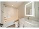 Modern bathroom with white subway tile shower and vanity with lighted mirror at 1933 W Trade St, Charlotte, NC 28216