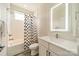 Bright bathroom features a shower-tub with white subway tile and a vanity with a lighted mirror at 1933 W Trade St, Charlotte, NC 28216