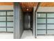 Modern townhome entrance with a wood ceiling, sleek door design, and glass garage doors at 1933 W Trade St, Charlotte, NC 28216