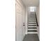 Entryway featuring staircase with a white door, a white and wood staircase, and tiled floors at 1933 W Trade St, Charlotte, NC 28216