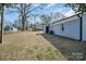 Picture of the backyard of a light blue brick house with large trees and patchy grass lawn at 200 W Shannonhouse St, Shelby, NC 28152