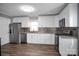 Updated kitchen features stainless steel appliances, granite countertops, and patterned backsplash at 200 W Shannonhouse St, Shelby, NC 28152