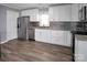 Updated kitchen features stainless steel appliances, granite countertops, and patterned backsplash at 200 W Shannonhouse St, Shelby, NC 28152