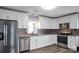 Bright updated kitchen with stainless steel appliances, white cabinetry, and decorative backsplash at 200 W Shannonhouse St, Shelby, NC 28152
