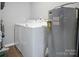 Functional laundry area with washer, dryer, and adjacent water heater at 200 W Shannonhouse St, Shelby, NC 28152