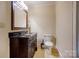 Well-lit half bathroom featuring a dark vanity and neutral walls at 235 John Rainey Rd, Salisbury, NC 28147