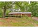 Charming brick ranch-style home nestled among mature trees with a well-maintained front yard at 235 John Rainey Rd, Salisbury, NC 28147