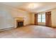 Spacious living room featuring a fireplace, neutral carpet, and large window at 235 John Rainey Rd, Salisbury, NC 28147