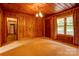 Living room with wood-paneled walls, a window, and carpeted floors at 235 John Rainey Rd, Salisbury, NC 28147