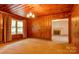Inviting living room with wood paneling, a window, and open access to other rooms at 235 John Rainey Rd, Salisbury, NC 28147
