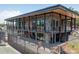 A modern two-story clubhouse featuring stone accents, wood trim, large windows, and outdoor balcony overlooking tennis courts at 2363 Shanklin S Ln, Denver, NC 28037