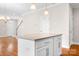 Kitchen island with pendant lighting, white cabinets, hardwood floors, and view of the stairway at 2363 Shanklin S Ln, Denver, NC 28037