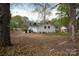 Expansive backyard featuring a white brick home, mature trees, and plenty of open space at 2408 Dora Dr, Charlotte, NC 28215