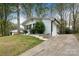 Exterior view of a white brick home with black trim, driveway and front yard at 2408 Dora Dr, Charlotte, NC 28215