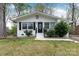 Quaint single-story house featuring a front yard, stone wall and front door with sidelight at 2408 Dora Dr, Charlotte, NC 28215