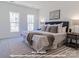 Main bedroom featuring two large windows, a gray upholstered bed, and minimalist decor at 282 Gilead Rd, Huntersville, NC 28078