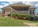 A landscaped backyard featuring a brick house with a screened-in porch, and green grass for outdoor enjoyment at 304 Wintergreen Ct, Kings Mountain, NC 28086