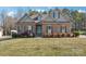 Inviting brick home with manicured landscaping, window shutters, dormers, and a bright front door at 304 Wintergreen Ct, Kings Mountain, NC 28086