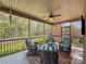 Enjoy outdoor living in this screened-in porch with cushioned seating, a ceiling fan, and views of the green backyard at 304 Wintergreen Ct, Kings Mountain, NC 28086