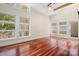 Sunlit bedroom with hardwood floors, a ceiling fan, and multiple windows overlooking lush greenery at 3249 Ivey Creek Rd, Maiden, NC 28650