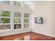 Bright bedroom with large windows showcasing wooded views and a wall-mounted television at 3249 Ivey Creek Rd, Maiden, NC 28650