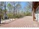 Spacious wood deck with an outdoor stone fireplace surrounded by trees at 3249 Ivey Creek Rd, Maiden, NC 28650