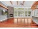 Large living room with a stone fireplace, wooden beam accents, and many bright windows at 3249 Ivey Creek Rd, Maiden, NC 28650