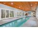Luxurious indoor pool area with a wood-paneled ceiling and multiple windows, providing a bright and inviting space at 3249 Ivey Creek Rd, Maiden, NC 28650