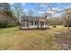 A well-kept bungalow set on a lawn with beautiful trees under a partly cloudy sky at 325 Hurley School Rd, Salisbury, NC 28147