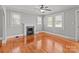 Bright living room with gleaming hardwood floors, fireplace, large windows and contemporary ceiling fan at 325 Hurley School Rd, Salisbury, NC 28147