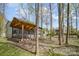 View of the backyard featuring a covered patio with a fire pit, surrounded by trees and greenery at 3846 Bent Creek Sw Dr # 58, Concord, NC 28027